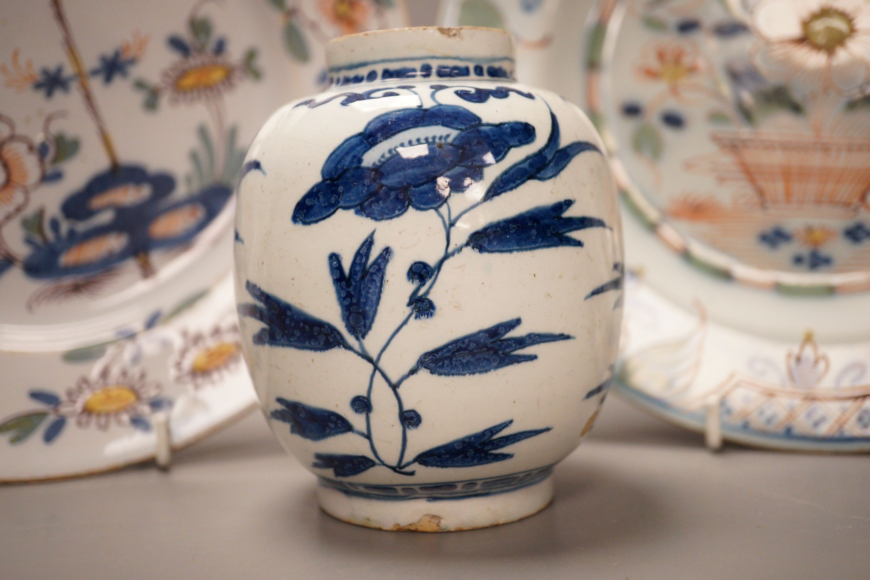 Two 18th century English delftware plates and a 18th century Delft vase, plate diameter 23cm (3)